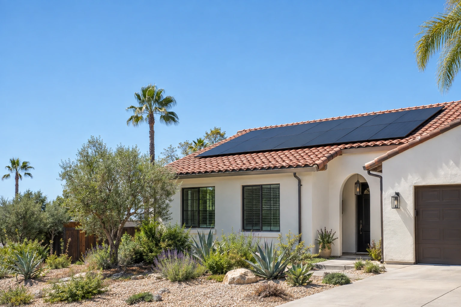 California home with a red clay tile roof and black solar panels