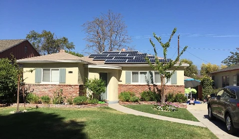 Ranch home with an asphalt shingle roof and solar array